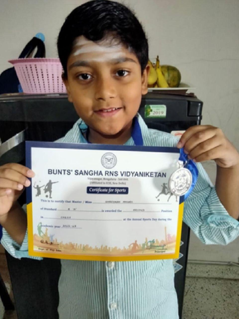 OMCA student with a sports certificate and medal
